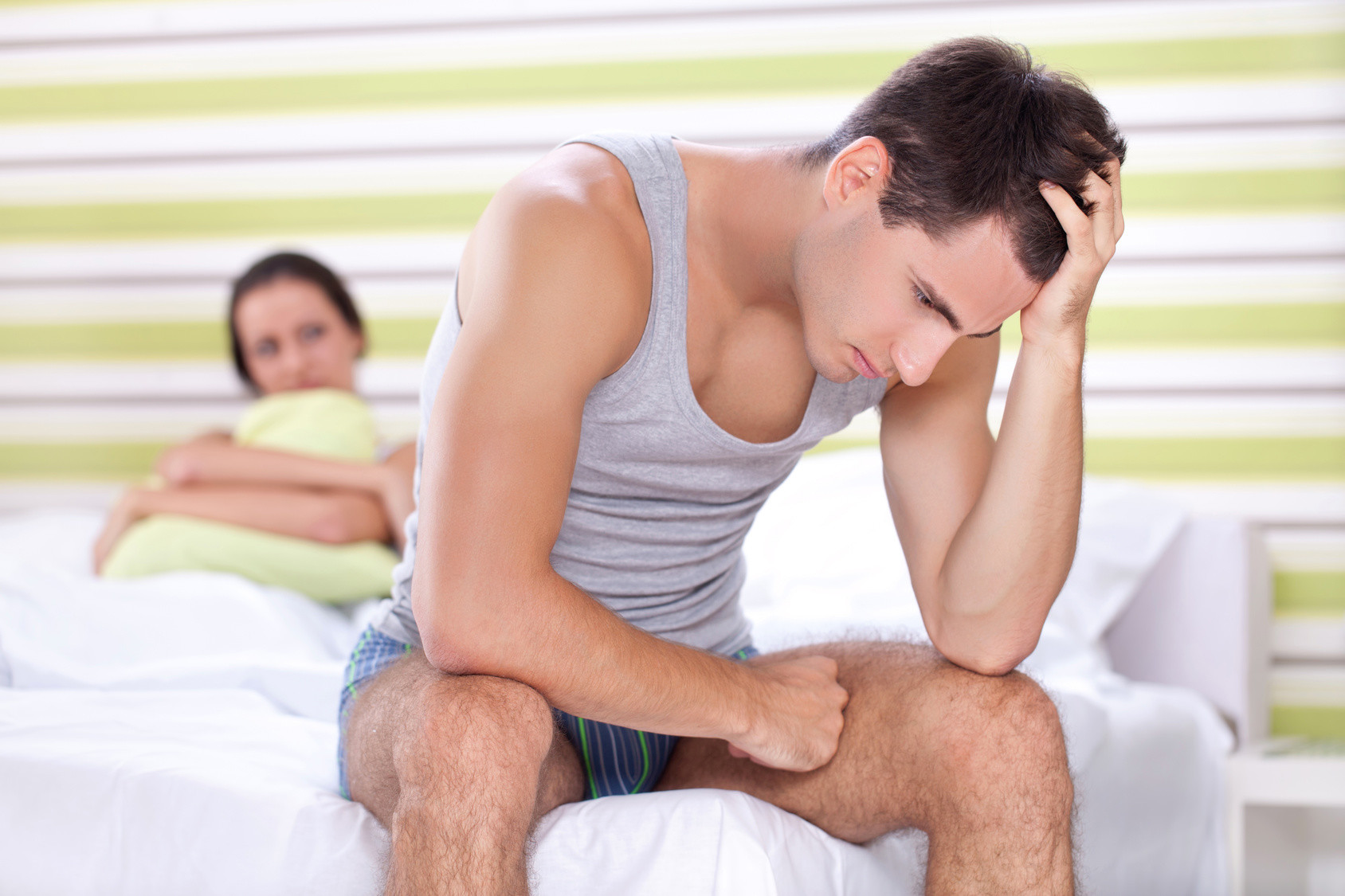 Unhappy young couple with problem in bedroom