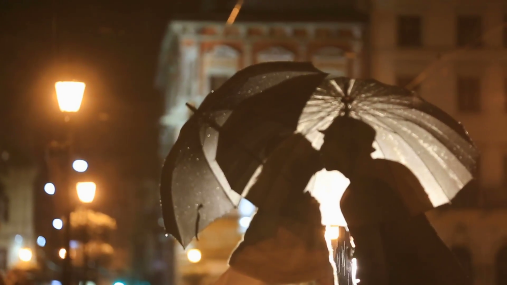 romantic-noir-styled-couple-under-rain-kissing-on-night-city-street-hiding-from-rain-under-umbrellas-city-lights-show-pair-silhouettes_sdu3l7si__F0000